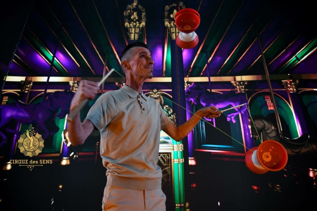 Inicio Manolo Carambolas - Espectáculo visual Imagine en escenario con iluminación morada con Diábolos