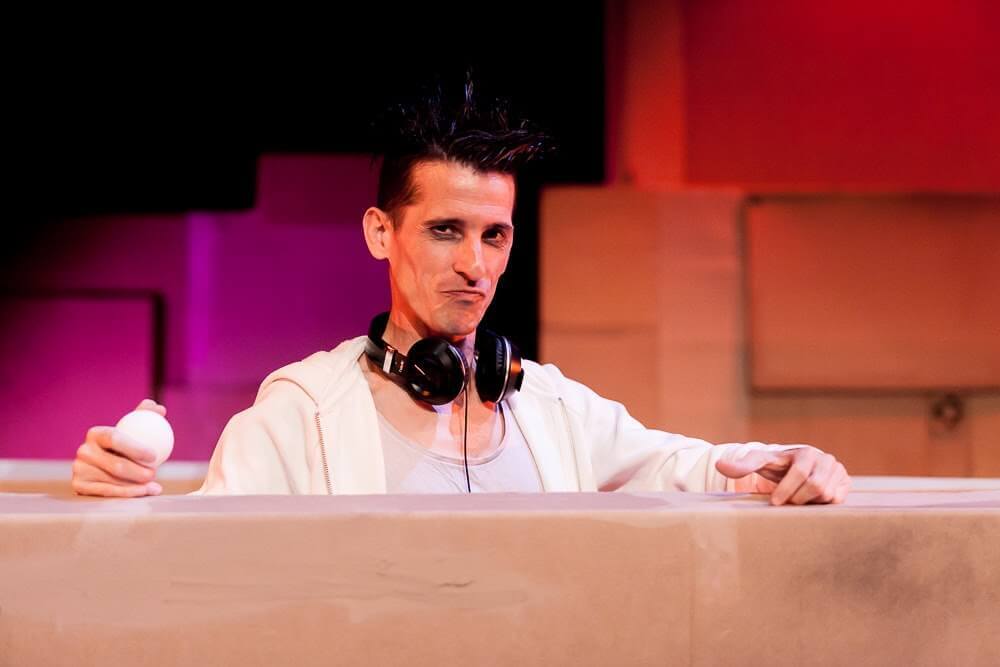 Primer plano de Manolo Carambolas con auriculares tras una estructura de madera en Ludo.