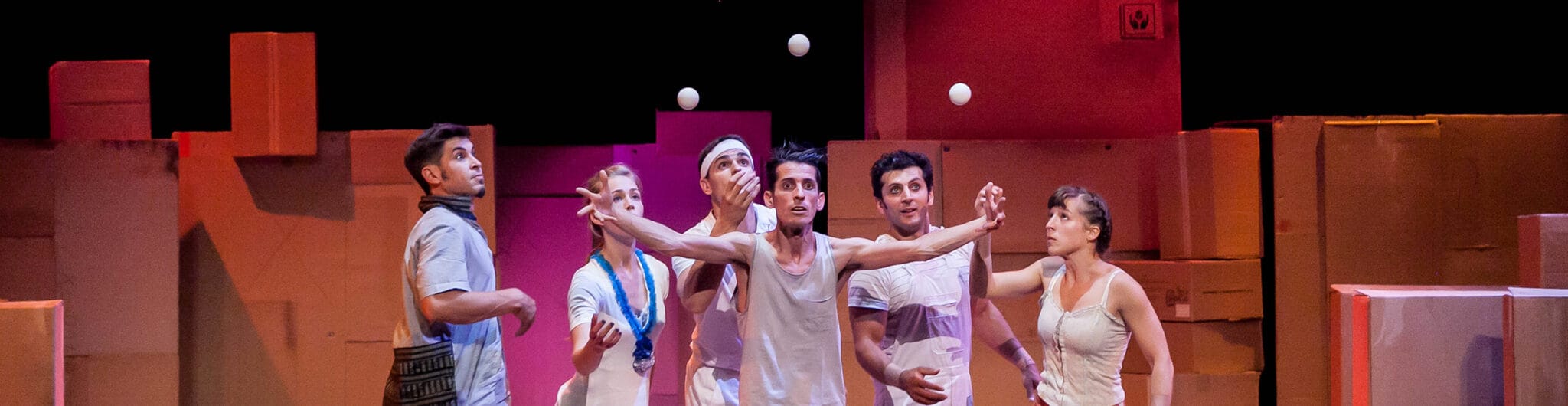 Elenco de artistas de Ludo Circus Show en un momento de la representación sobre el escenario, destacando la combinación de circo contemporáneo y juego.